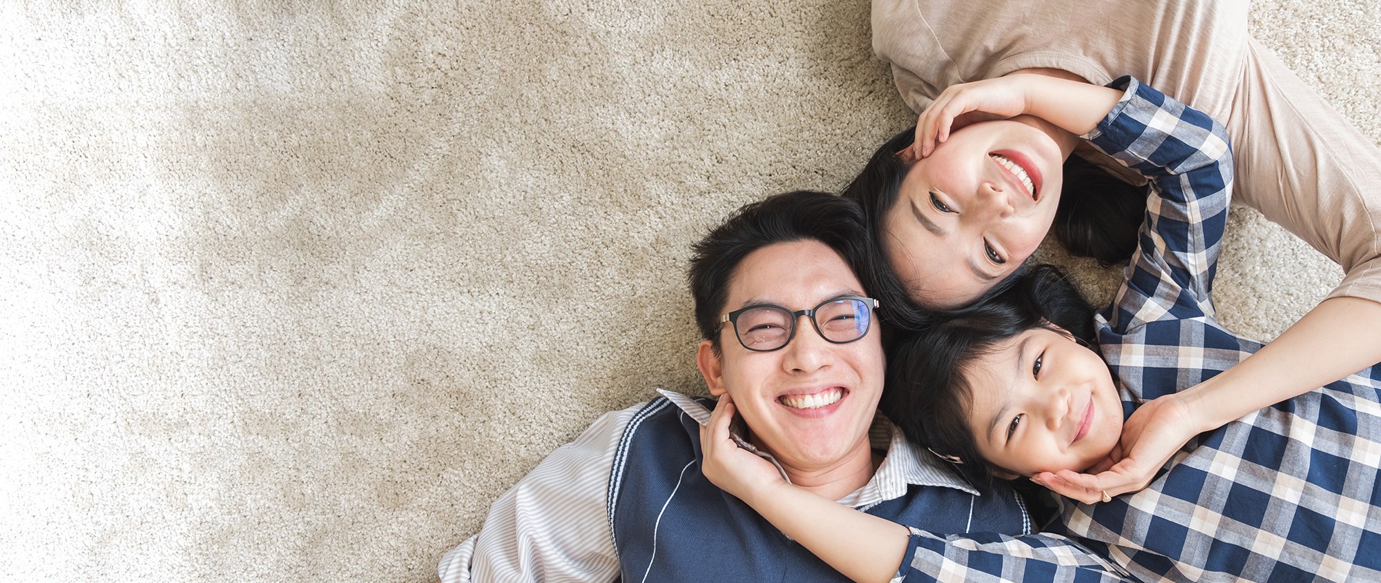 a family of three smiling on the floor