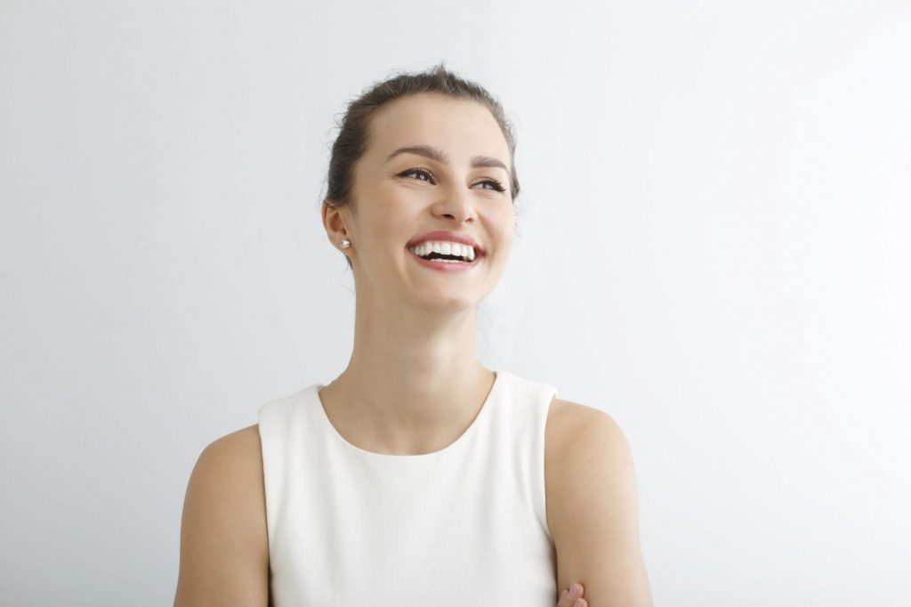 a woman in a white top smiling
