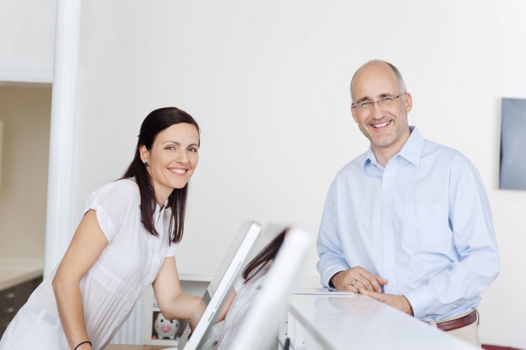 a man and woman at a dentist office desk